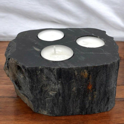 Alt Tag: Triple Petrified Wood Candle Holder – Natural Stone, dark petrified wood slab candle holder with three tea light candles