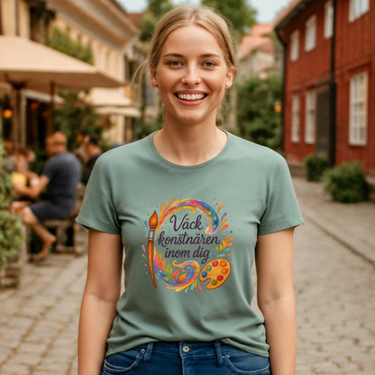Alt Tag: Väck Konstnären Inom Dig Waldorf Sustainable Unisex Tee på modell i grön t-shirt med konstnärlig färgpalett- och penselgrafik