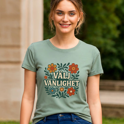 Alt Tag: Välj Vänlighet t-shirt i 100% ekologisk bomull på modell, salviagrön t-shirt med "VÄLJ VÄNLIGHET" och blommotiv