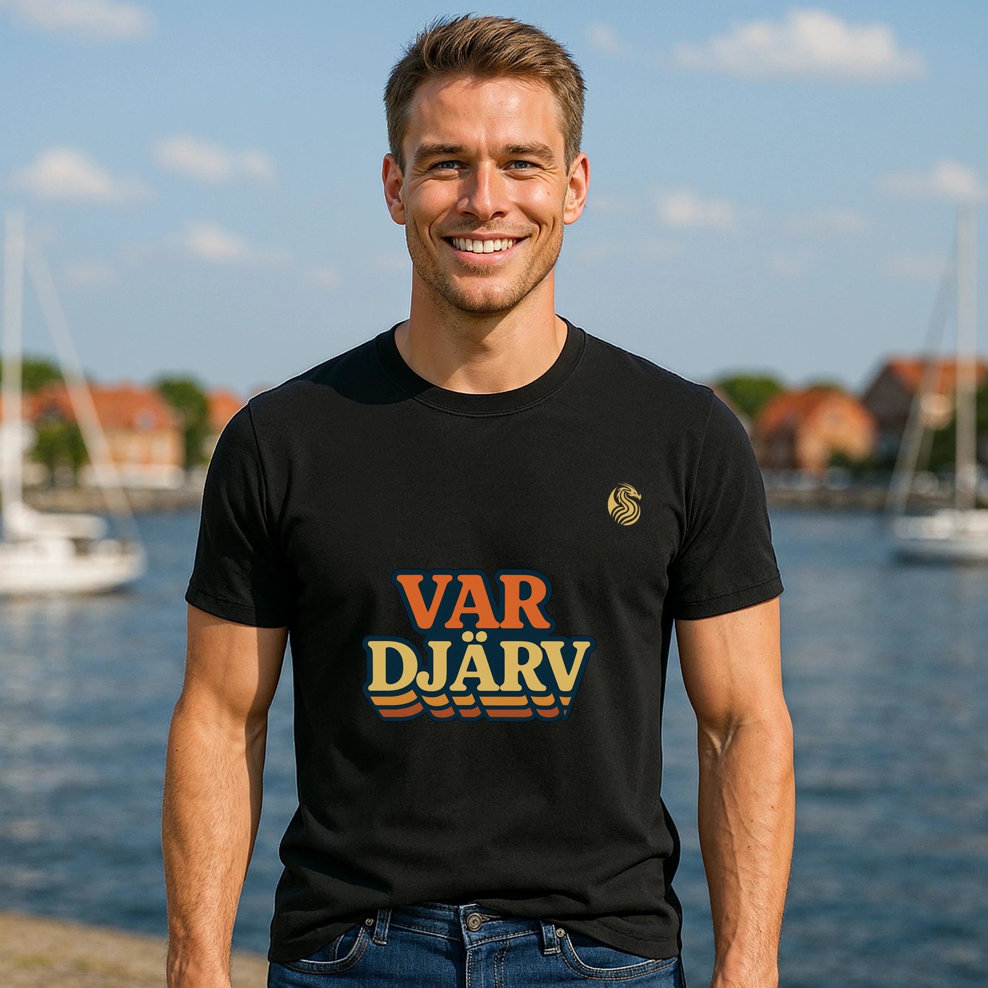 Var Djärv Ungdom 100% Organic Cotton T-Shirt on model wearing black "VAR DJÄRV" graphic tee by the water
