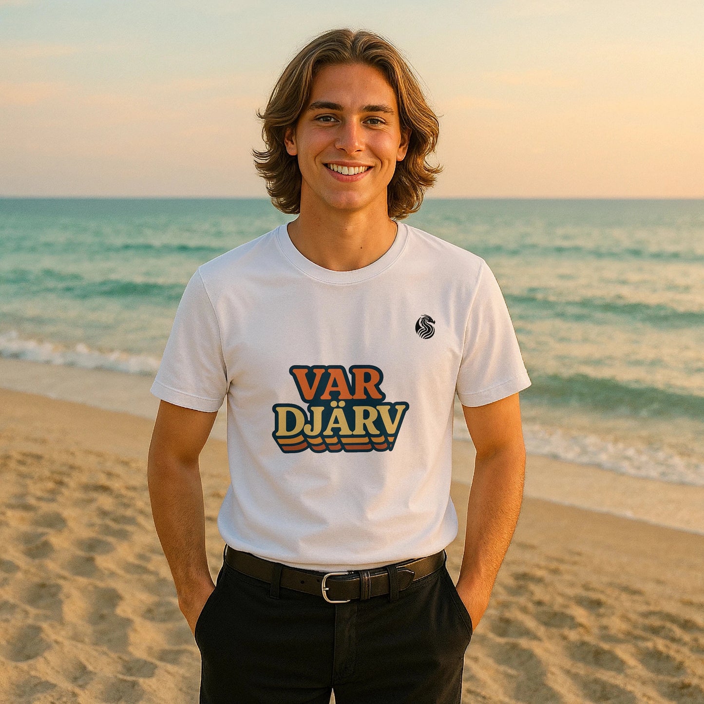 Var Djärv Ungdom 100% Organic Cotton T-Shirt en blanco con logo VAR DJÄRV, modelo sonriente en la playa al atardecer