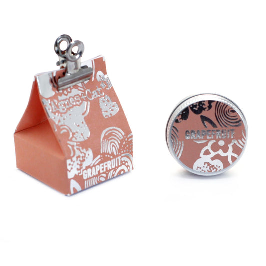 Vegan Grapefruit Lip Balm – 12G in round tin with grapefruit label, shown beside branded orange display box