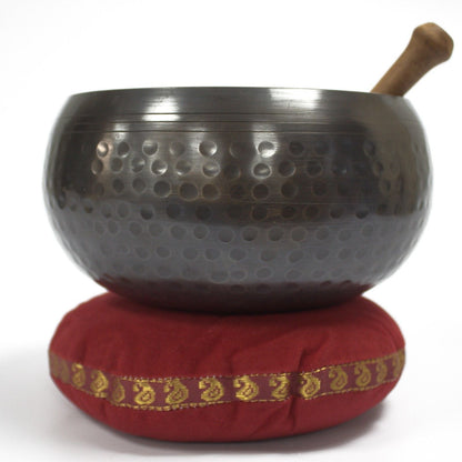 Velvet Singing Bowl Cushion – 11CM red velvet cushion with gold trim supporting a metal Tibetan singing bowl and wooden striker