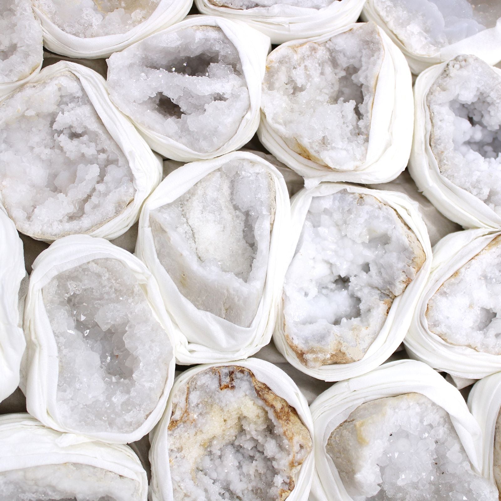 Alt Tag: Vibrant Calcite Mineral Specimens – Approx 32 Pieces, close-up of white calcite crystal geode halves wrapped in protective paper