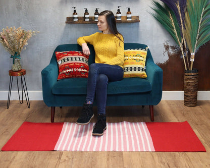 Livfull bomullsmatta – 70x173 CM, röd/rosa i vardagsrum under turkos soffa med randig röd-rosa design och dekorativa kuddar