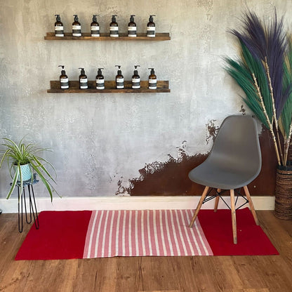 Alt Tag: Färgstark bomullsmatta – 70x173 CM, röd/rosa på trägolv med grå stol, hyllor och dekorativa växter