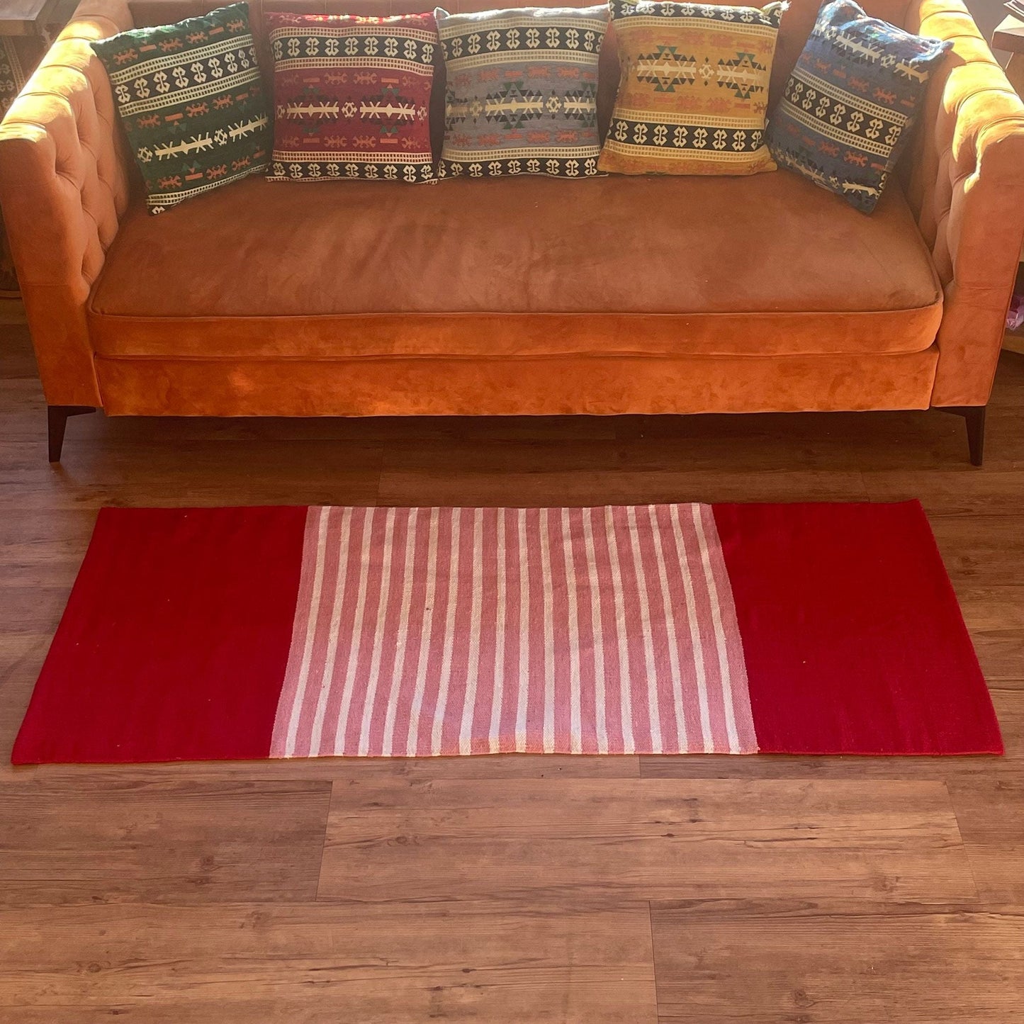Färgstark bomullsmatta – 70x173 CM, röd/rosa på trägolv framför soffan, röd matta med rosa- och vitrandig mittpanel