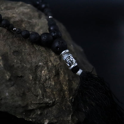 Alt Tag: Volcanic Bead Necklace – Grounding Energy con cuentas negras de piedra volcánica, detalle plateado tipo Buda y borla negra