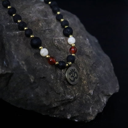 Volcanic Bead Om Necklace – 42 CM con cuentas volcánicas negras, gemas rojas y blancas y colgante Om sobre roca oscura