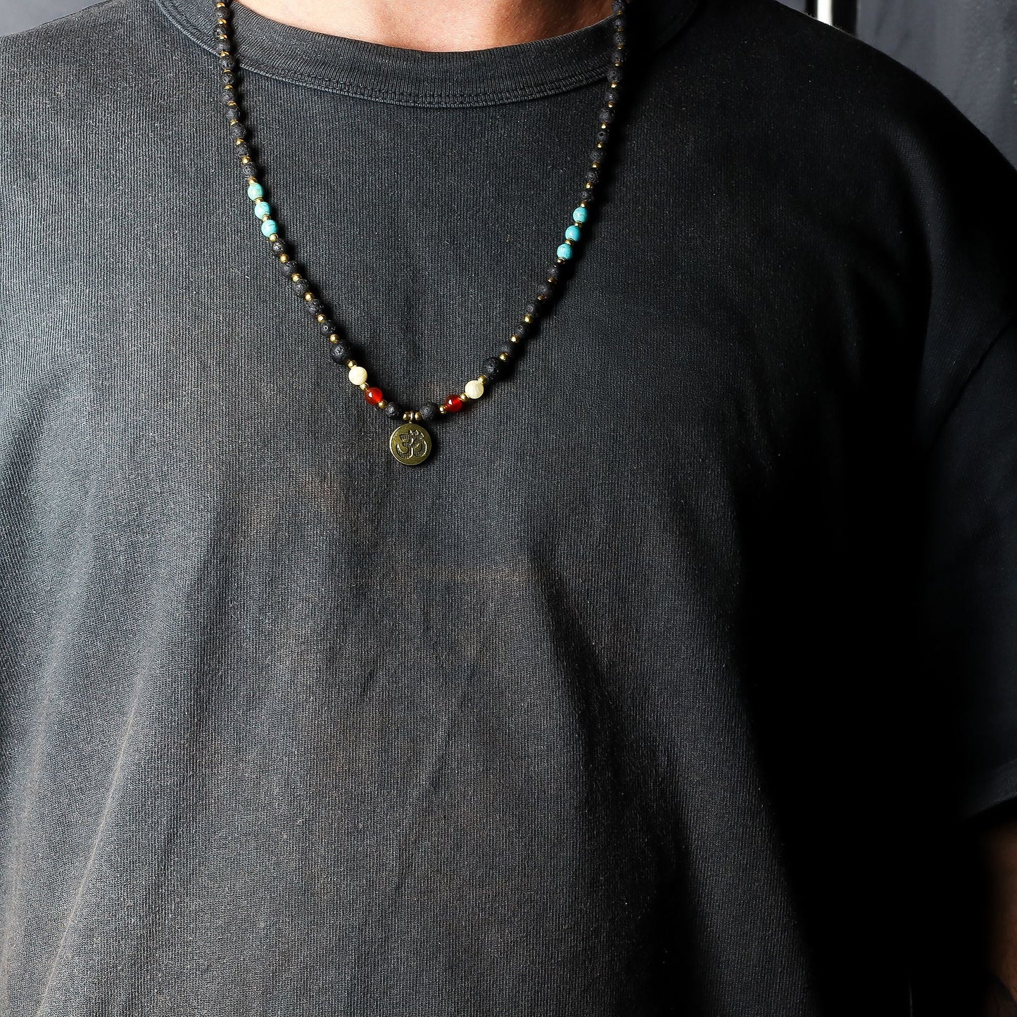Volcanic Bead Om Necklace – 42 CM con cuentas volcánicas negras, piedras de colores y colgante Om, mostrado en cuello