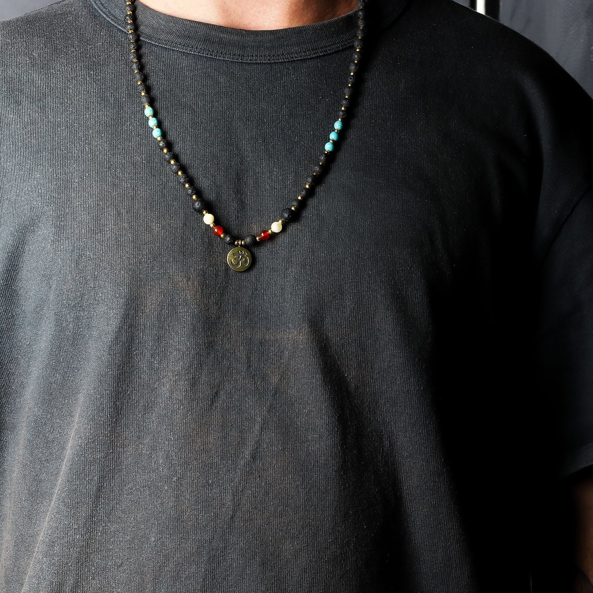 Volcanic Bead Om Necklace – 42 CM con cuentas volcánicas negras, piedras de colores y colgante Om, mostrado en cuello