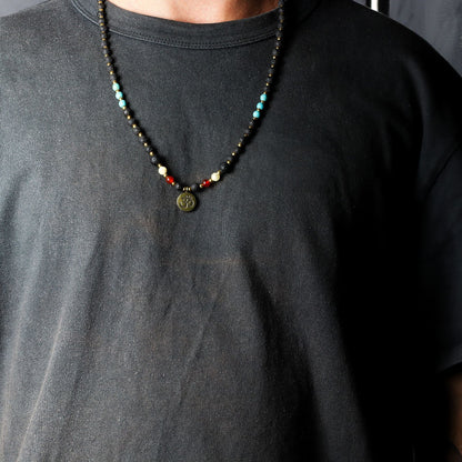 Volcanic Bead Om Necklace – 42 CM con cuentas volcánicas negras, piedras de colores y colgante Om, mostrado en cuello