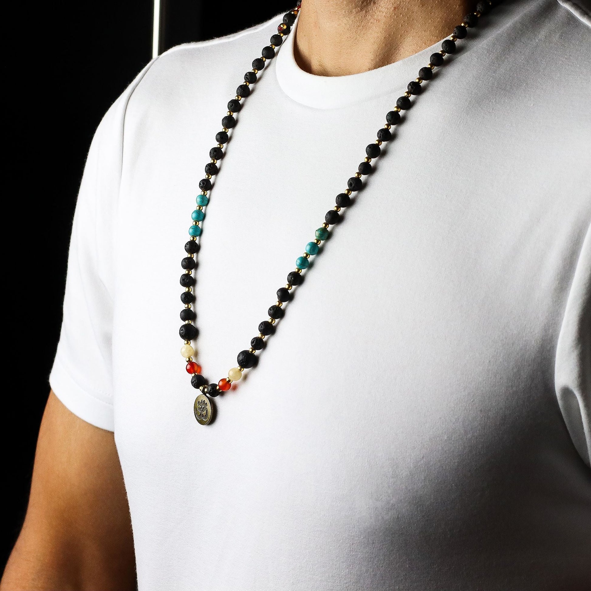 Volcanic Bead Om Necklace – 42 CM on model, black volcanic beads with turquoise, red and white gemstone accents, Om pendant