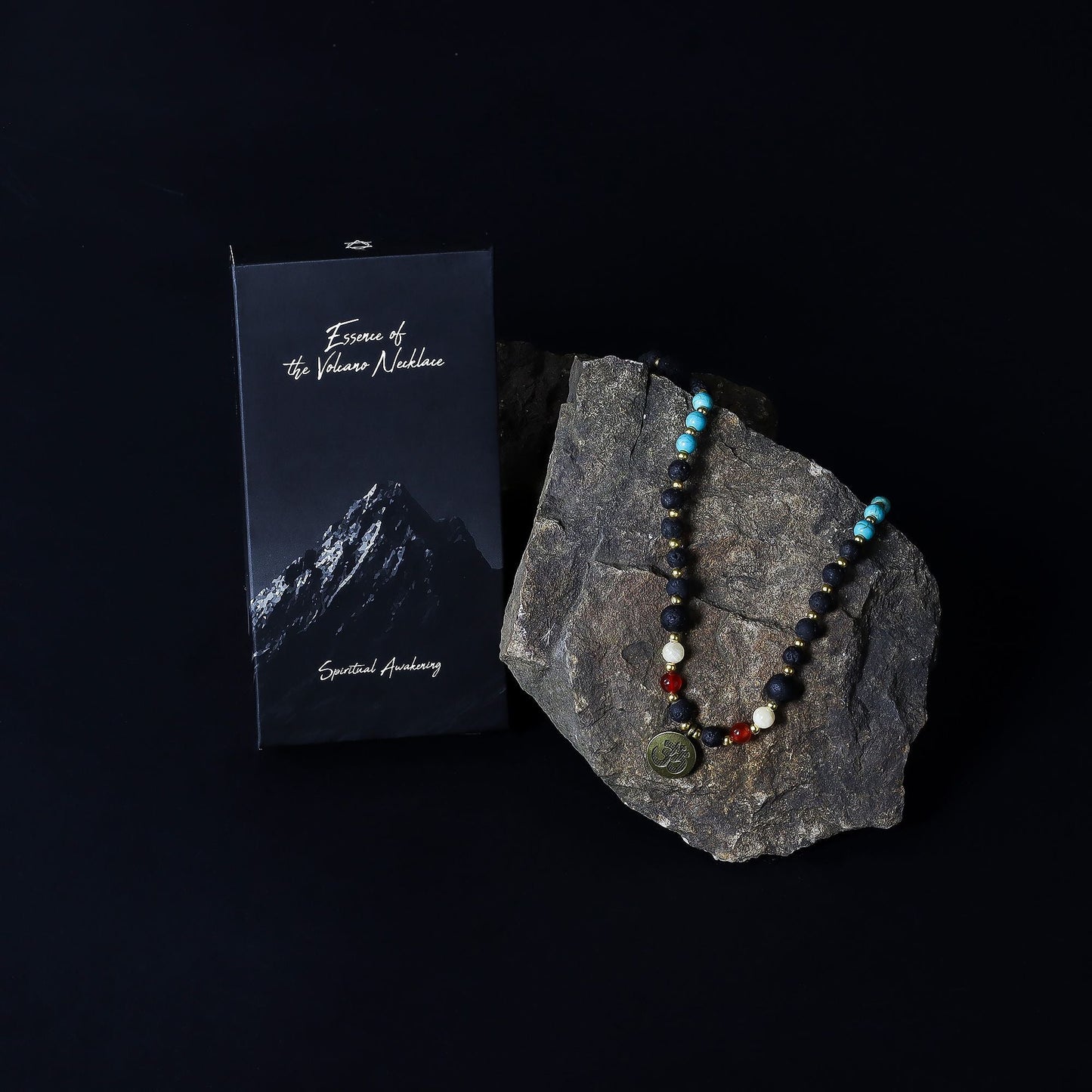 Volcanic Bead Om Necklace – 42 CM on rock display with gemstone beads and Om pendant, photographed beside product booklet