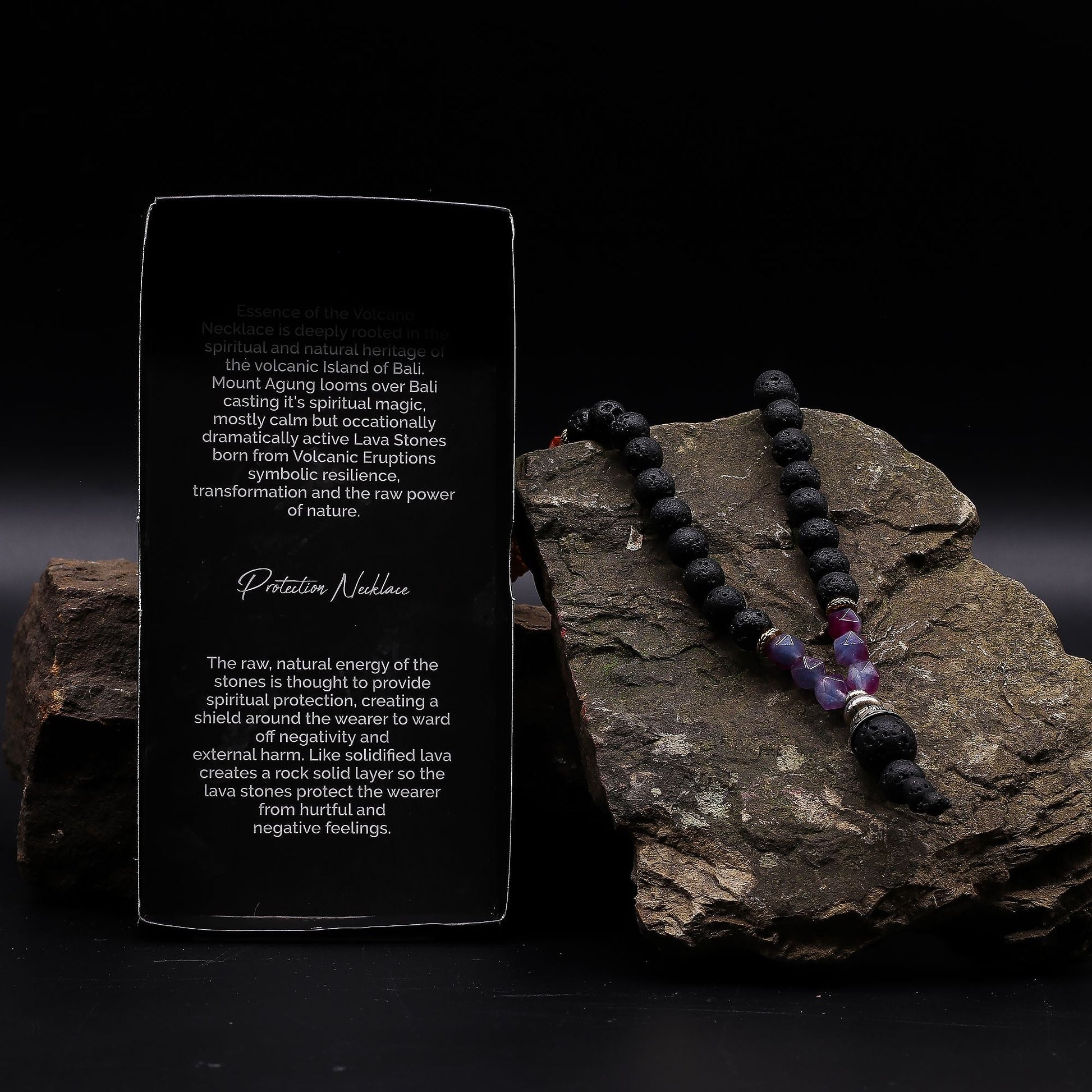 Volcanic & Gemstone Necklace – Embrace Dark Side with black lava stone and gemstone beads displayed on rock beside product card