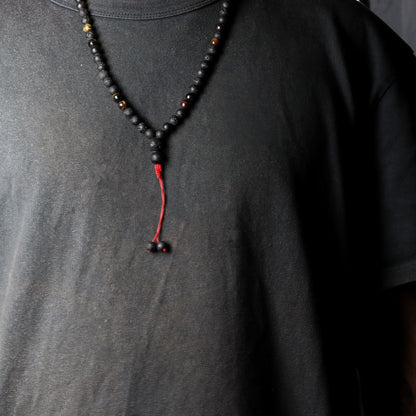 Volcanic Lava & Tiger's Eye Necklace – 42CM black beaded necklace with red tassel on model wearing black shirt