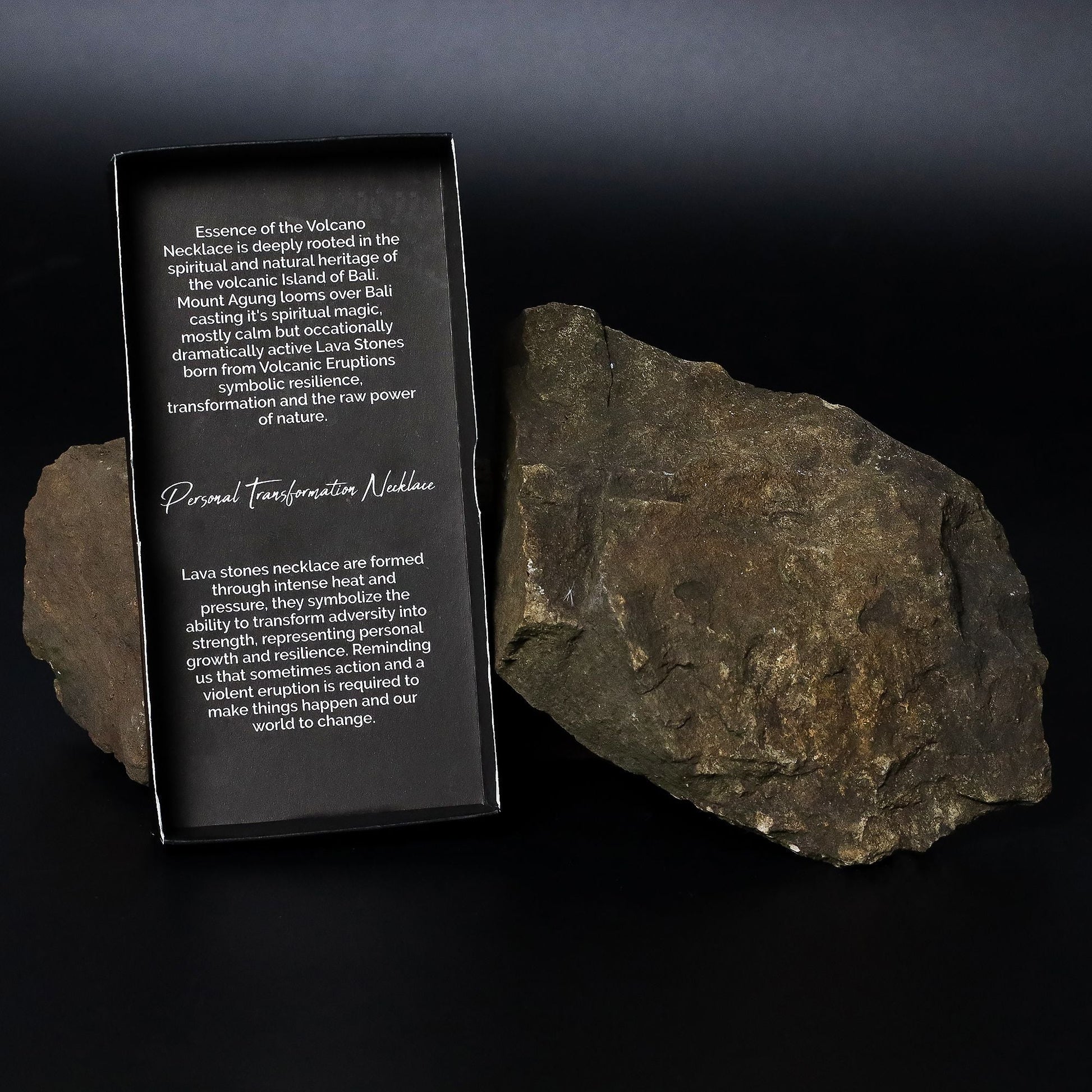 Alt Tag: Volcanic Lava & Tiger's Eye Necklace – 42CM packaging card beside volcanic lava stone rock on black background
