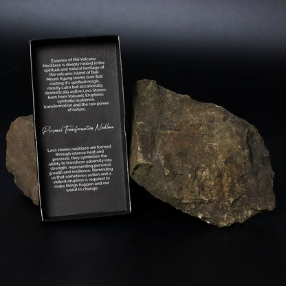 Alt Tag: Volcanic Lava & Tiger's Eye Necklace – 42CM packaging card beside volcanic lava stone rock on black background