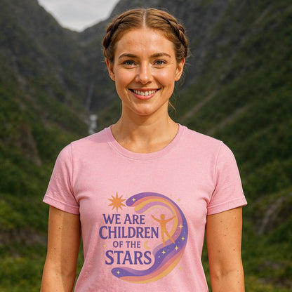 We Are Children Of The Stars 100% Organic Cotton T-Shirt on woman wearing pink graphic tee outdoors with mountains