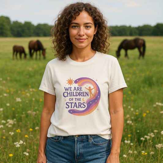 We Are Children Of The Stars 100% Organic Cotton T-Shirt worn by woman, cream tee with colorful moon and star graphic, outdoors