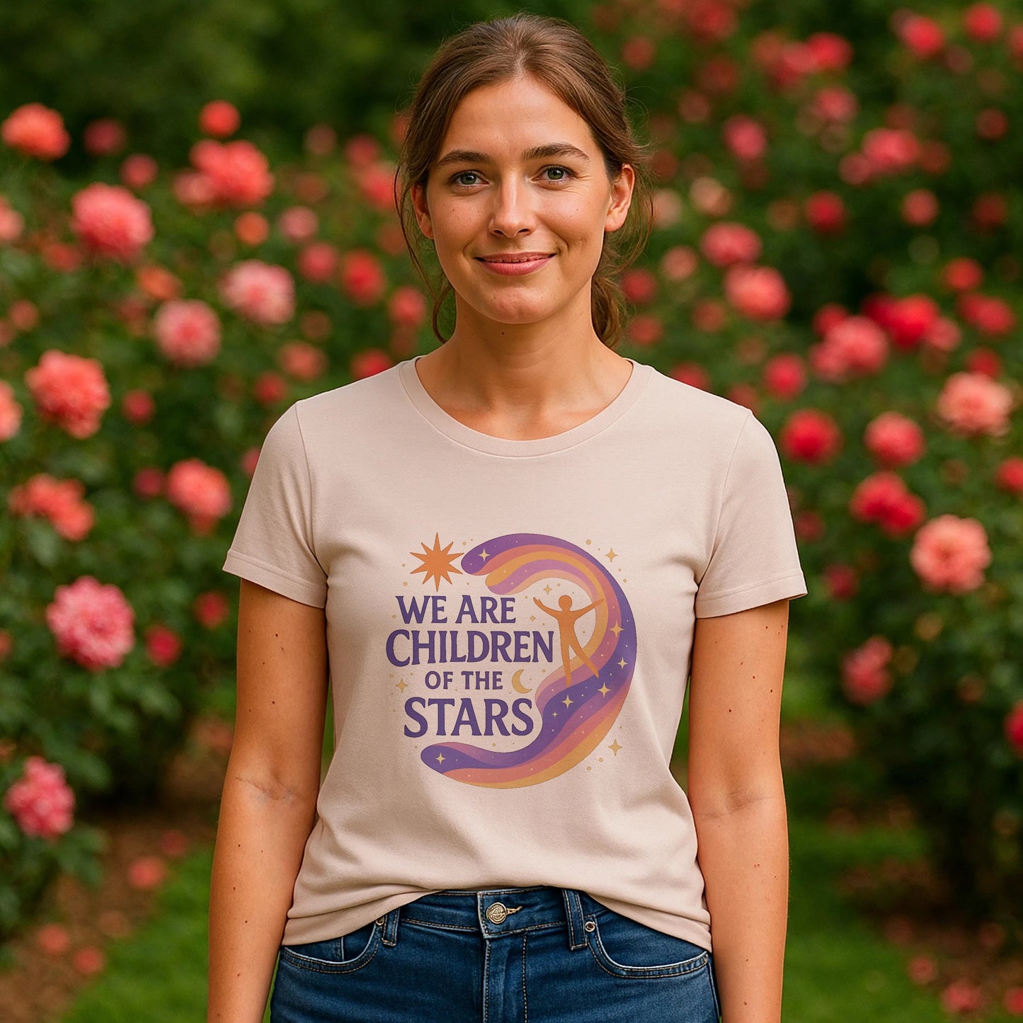 We Are Children Of The Stars 100% Organic Cotton T-Shirt on model, beige tee with cosmic graphic and text, outdoor garden setting