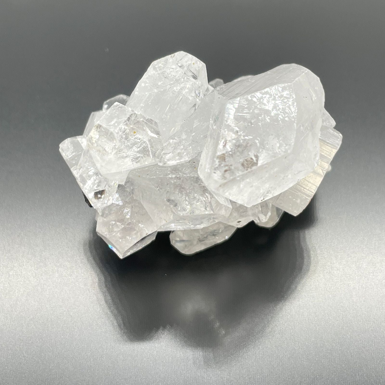 White Apophyllite Clusters – 20–30 MM natural white crystal cluster specimen with clear, reflective points on dark background