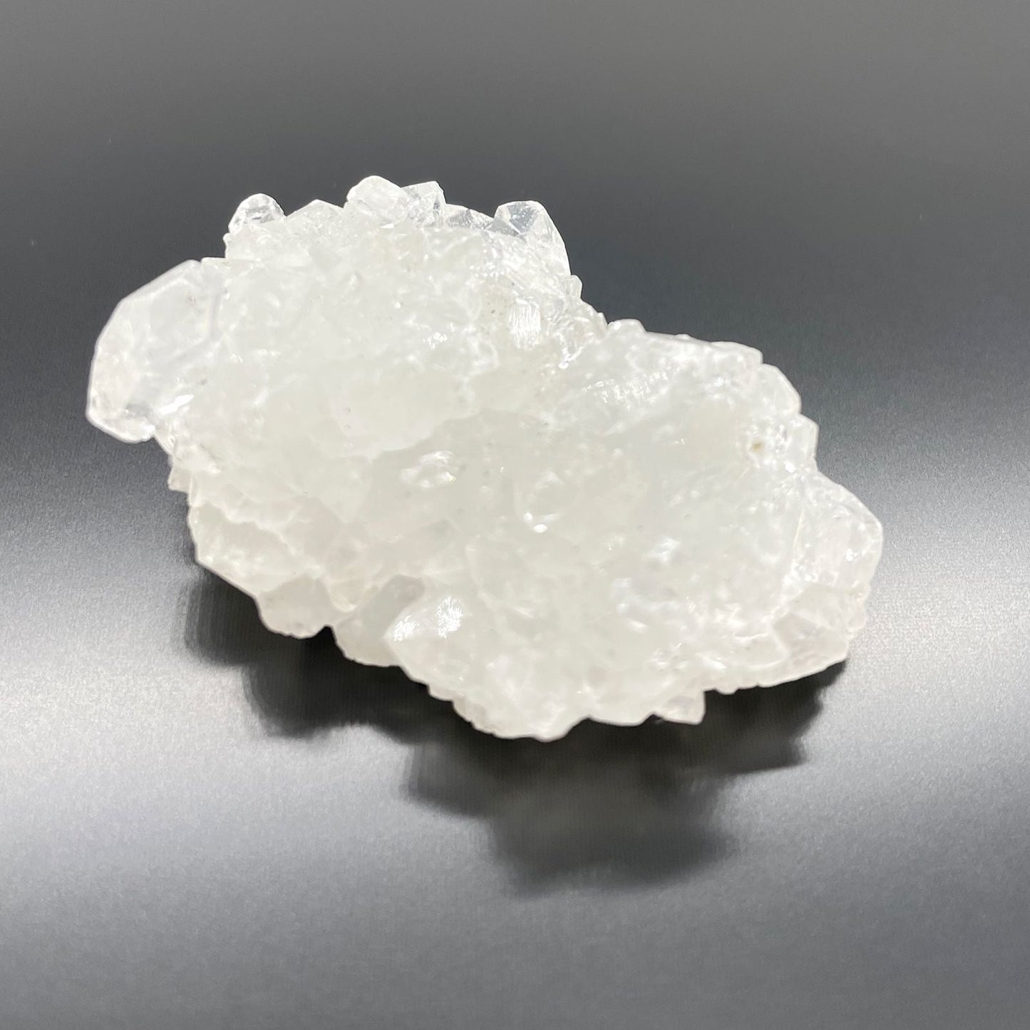 White Apophyllite Clusters – 20–30 MM cristal natural blanco en racimo, textura brillante sobre fondo gris