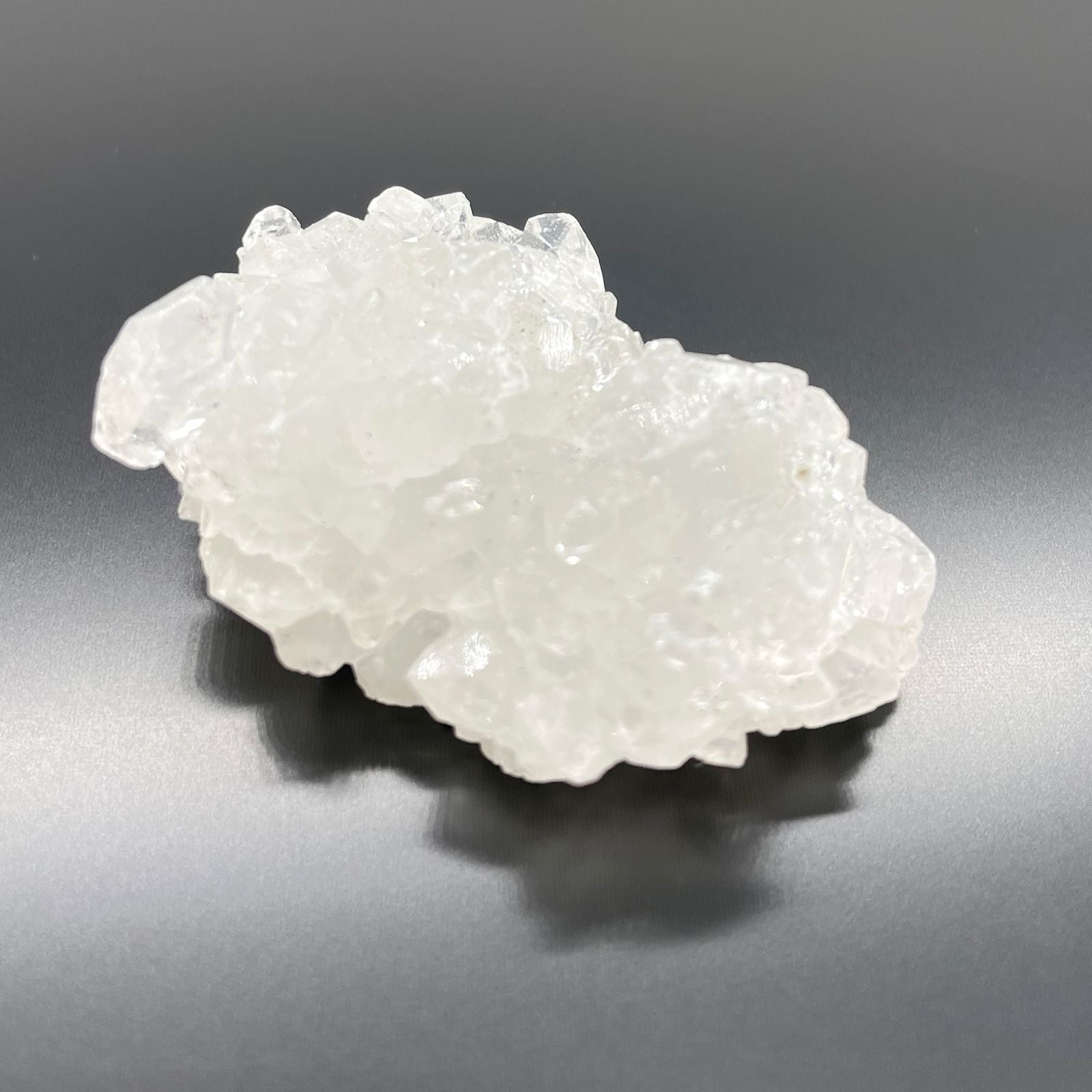 White Apophyllite Clusters – 20–30 MM cristal natural blanco en racimo, textura brillante sobre fondo gris