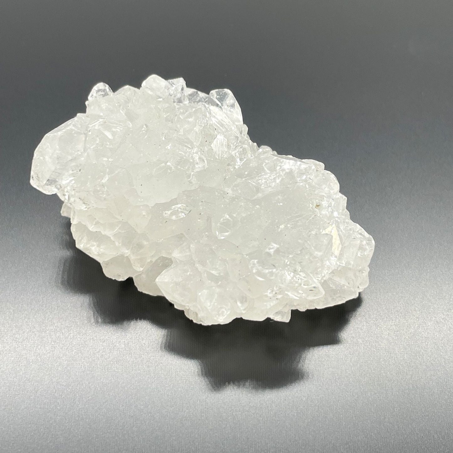 Alt Tag: White Apophyllite Clusters – 20–30 MM natural white crystal cluster specimen, translucent points on dark background