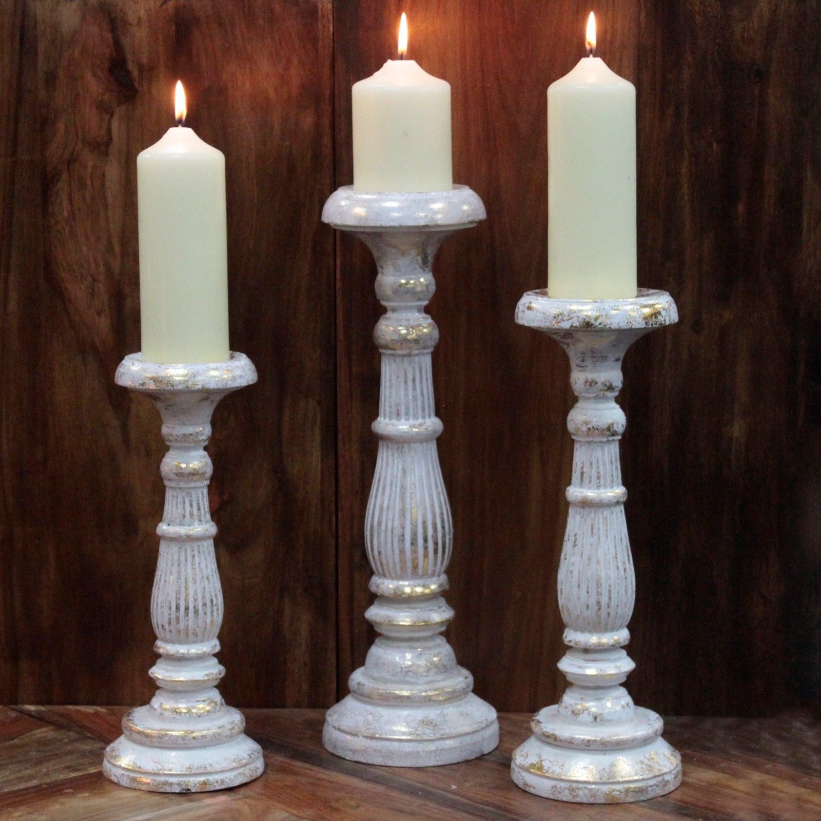 Soporte grande para velas en oro blanco – Portavelas altos decorativos de metal blanco con sutiles detalles dorados, sosteniendo velas de pilar blancas encendidas