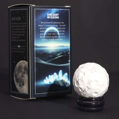 White Howlite Gemstone Planet – 40MM Solar Goldstone Stand with cratered white sphere on sparkling dark stand beside product box