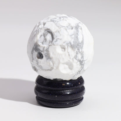 Alt Tag: White Howlite Gemstone Planet – 40MM Solar Goldstone Stand, white howlite sphere with gray veining on dark sparkling stand