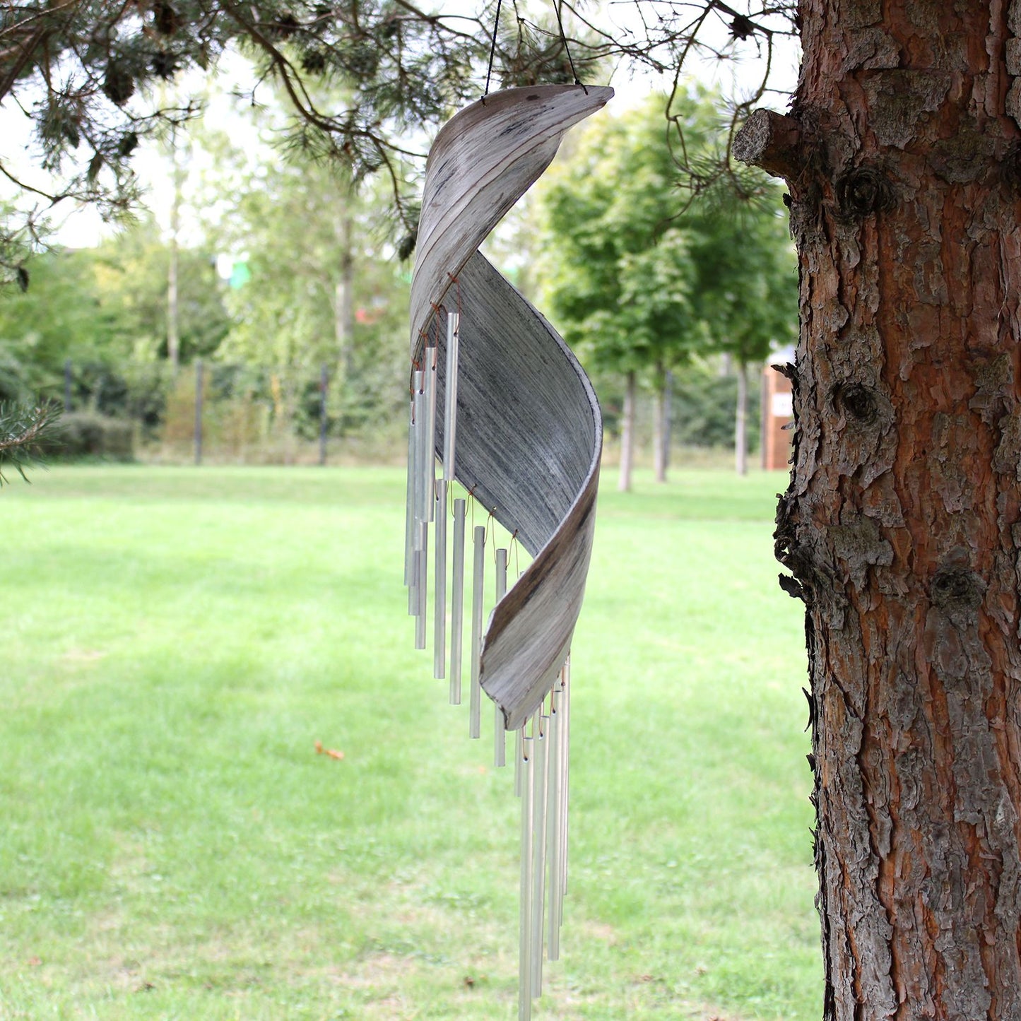 Alt Tag: Whitewashed Coconut Leaf Wind Chimes – 50x13 CM colgando de un árbol en jardín, chimes artesanales de hoja de coco blanqueada