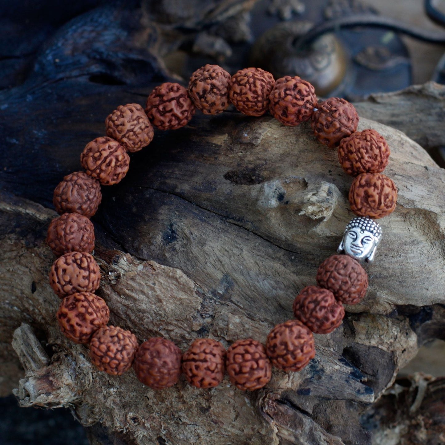 Alt Tag: Wood Bead Buddha Bangle Mala – Brown bracelet with natural Rudraksha beads and Buddha charm on rustic wood background