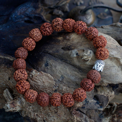 Alt Tag: Wood Bead Buddha Bangle Mala – Brown bracelet with natural Rudraksha beads and Buddha charm on rustic wood background