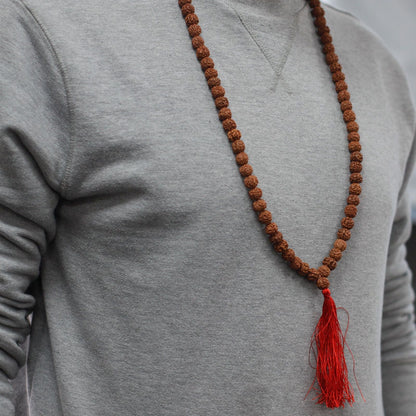 Alt Tag: Wood Bead Rudraksha Mala – 65 CM collar de cuentas Rudraksha marrones con borla roja, usado sobre sudadera gris
