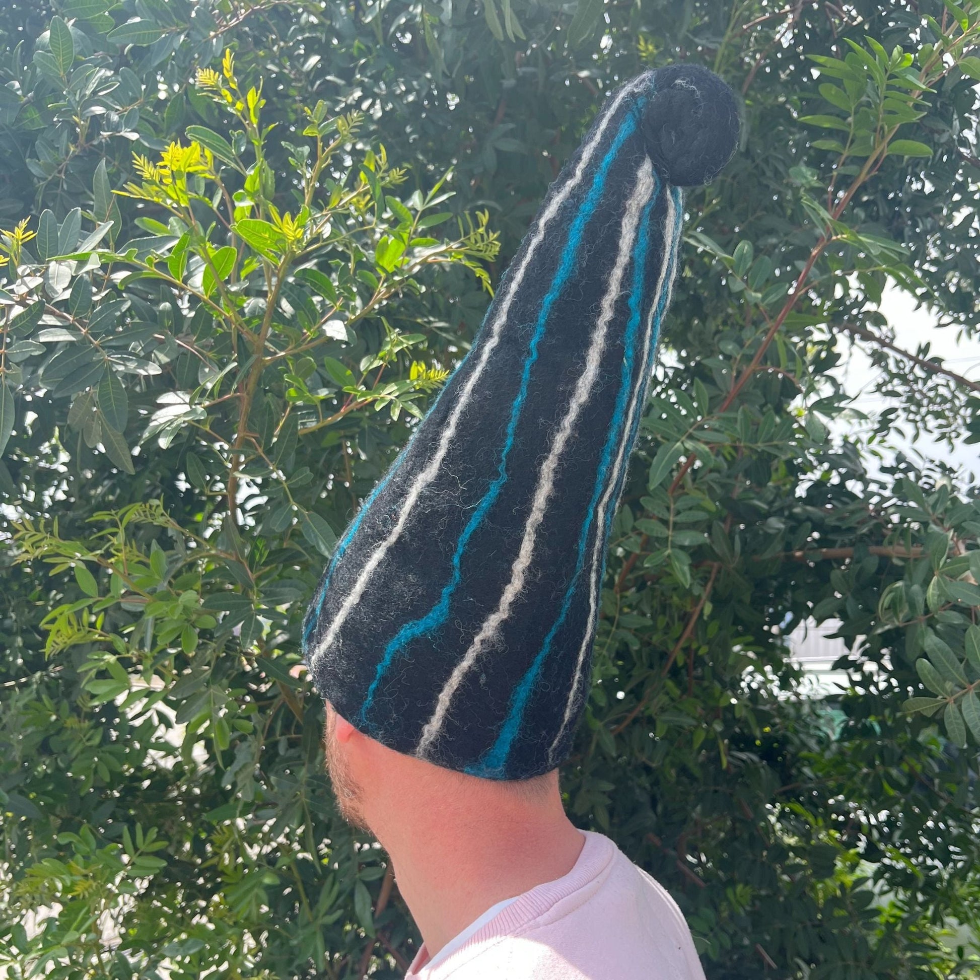 Alt Tag: Wool Felted Sauna Wizard Hat – Black Blue Streaks, tall felt wool sauna hat with blue and white streaks, side view