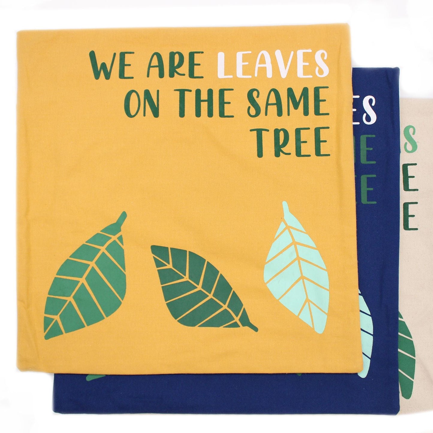Gult kuddfodral i bomull – 45x45 CM med texten “WE ARE LEAVES ON THE SAME TREE”, bladdesign, bakre dragkedja