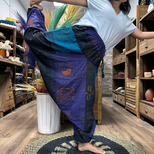 Yoga- och festivalbyxor – Aladdin Himalayan Print on Purple Haremsbyxor i Aladdin-stil i 100% bomull i djup lila, fotograferade i en yogaposition