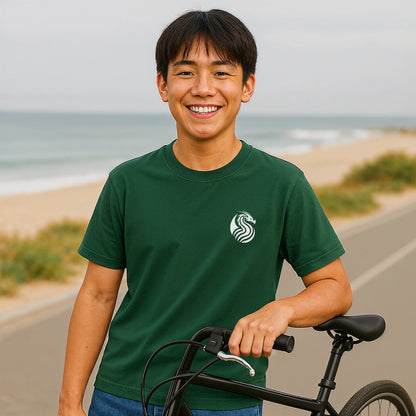 Alt Tag: Young Dragon Premium Unisex T-Shirt in green with dragon logo, worn by model holding bicycle near beach road